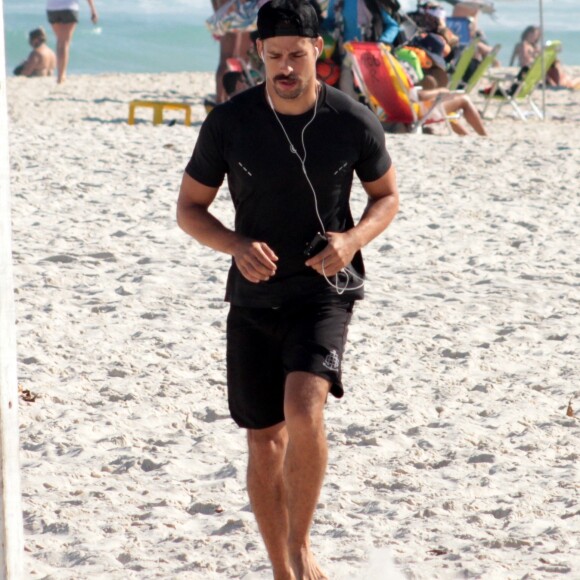 Cauã Reymond corre sozinho ouvindo música em praia