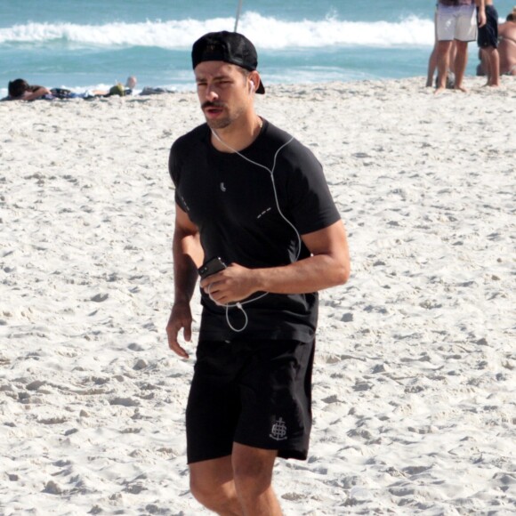 Cauã Reymond ouve música ao se exercitar em praia do Rio