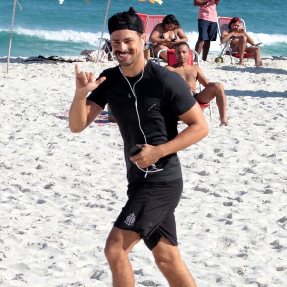 Cauã Reymond acena para paparazzi ao correr em praia da Barra da Tijuca, no Rio de Janeiro, em 4 de junho de 2017