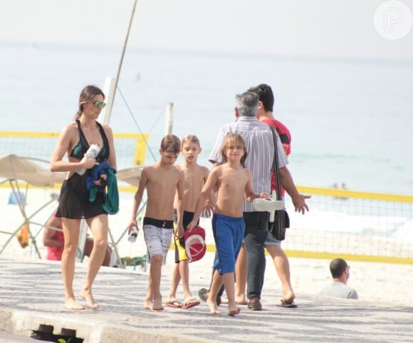Fernanda Lima se diverte ao ir à praia com os filhos gêmeos, Francisco (de bermuda branca) e João (de preto)
