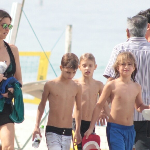 Fernanda Lima se diverte ao ir à praia com os filhos gêmeos, Francisco (de bermuda branca) e João (de preto)