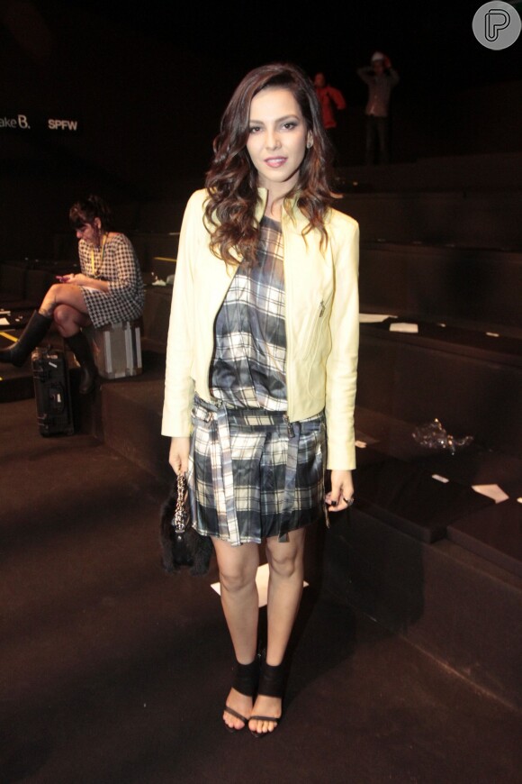 A atriz combinou o vestido xadrez com uma jaqueta de couro para ir ao desfile da Animale no São Paulo Fashion Week. Tudo da grife: vestido à venda por R$ 798, a jaqueta custa R$ 2.198, a sandália vale R$ 498 e a clutch de pelos sai por  R$ 498