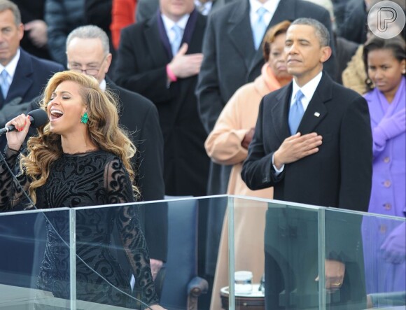 Beyoncé canta o hino nacional (com playback, segundo 'TMZ') enquanto o presidente Barack Obama leva a mão ao peito em sinal de respeito à patria, em 21 de janeiro de 2013