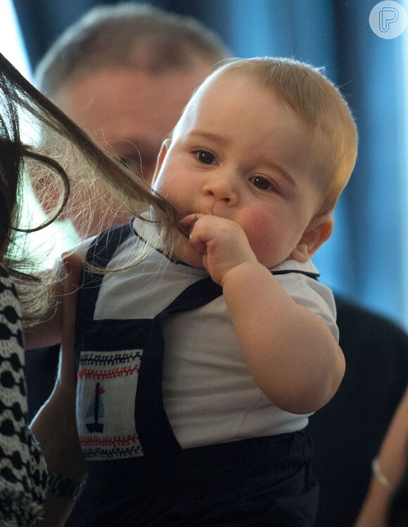 Príncipe George, filho de Kate Middletlon e do Príncipe William, põe o cabelo na boca durante visita a instituição na Nova Zelândia