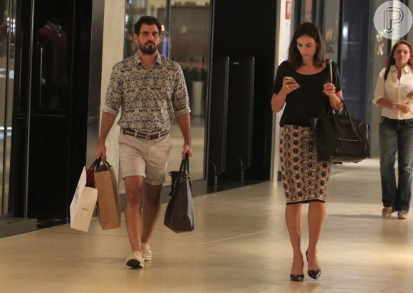 Juliano Cazarré carrega as sacolas de compras no shopping