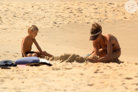 Fernanda Lima ajuda João e Francisco na missão de cavar um enorme buraco na areia da praia do Leblon, Zona Sul do Rio de Janeiro