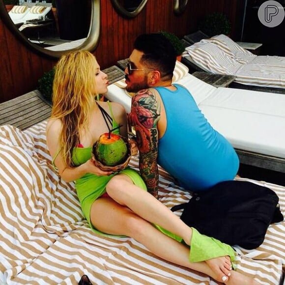 Avril Lavigne bebe água de coco em piscina de hotel no Rio de Janeiro