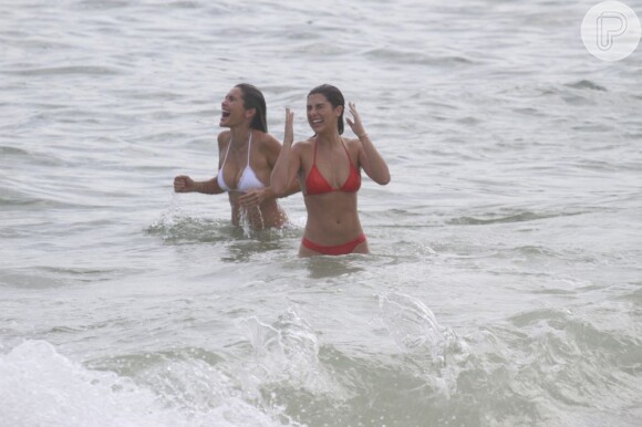 Flávia Alessandra e Fernanda Paes Leme gritam ao entrar na água, provavelmente por causa da água fria