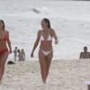 Flávia Alessandra e Fernanda Paes Leme gargalham ao andar na areia da praia do Recreio