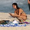Isis Valverde checa o celular em praia no Rio de Janeiro