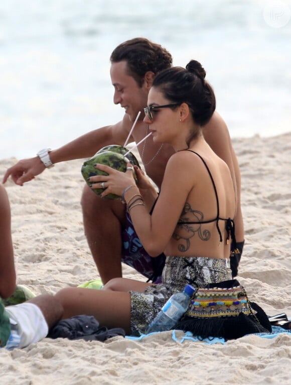 Isis Valverde bebe água de coco na praia em 6 de maio de 2014