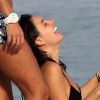 Isis Valverde gargalha entre amigos, na praia, após se livrar de colar cervical