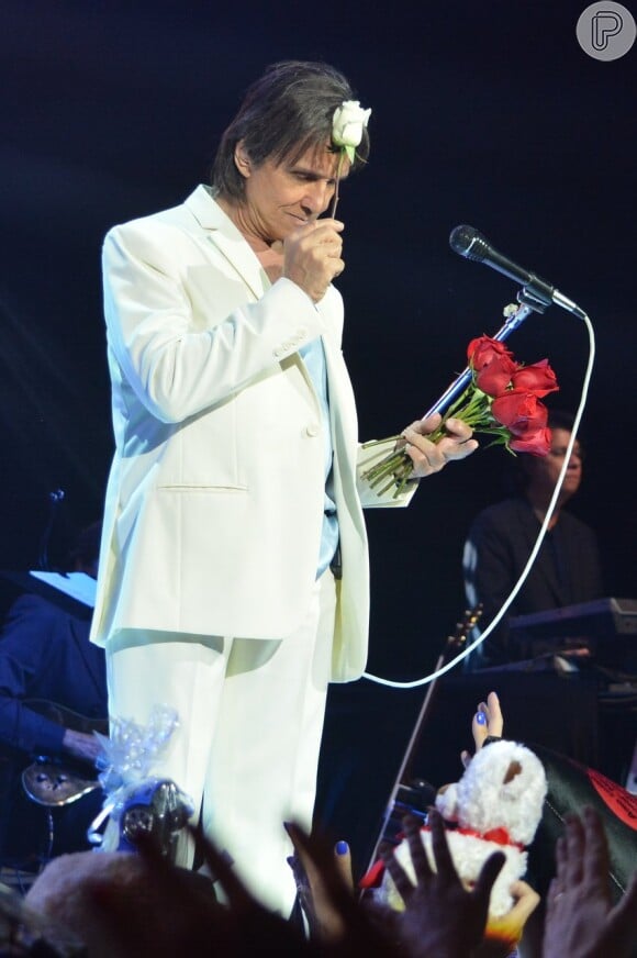Roberto Carlos beija rosas e faz a tradicional entrega para as fãs da plateia