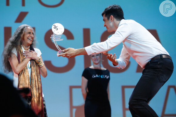Mateus Solano reverencia a cantora Maria Bethânia ao entregar o troféu no palco do Theatro Municipal