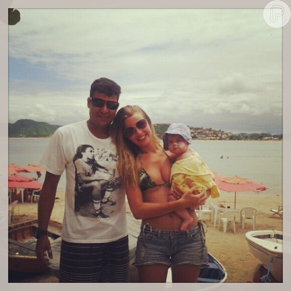 Debby Lagranha carrega a pequena Maria Eduarda acompanhada do marido, Leandro Franco para a praia