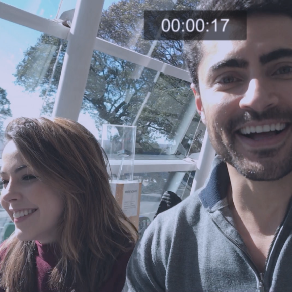 Gustavo (Carlo Porto) faz vídeos de Cecília (Bia Arantes) no aeroporto para que ela perca o medo de voar de avião, na novela 'Carinha de Anjo'