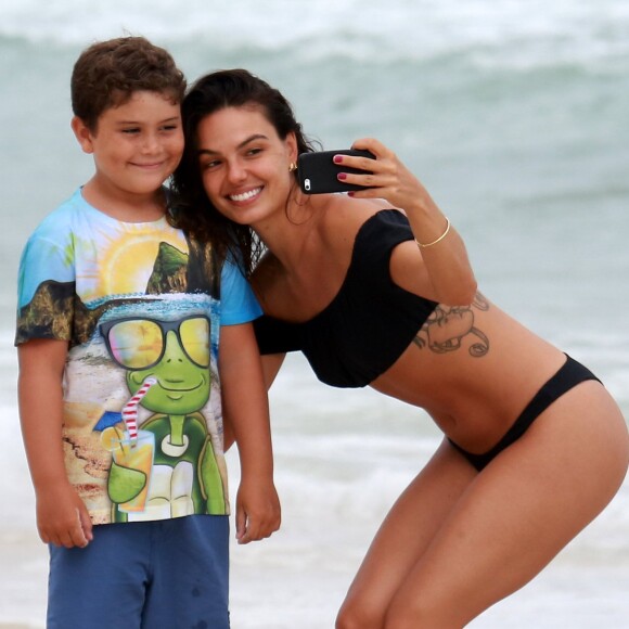 Isis Valverde posa com fã mirim em praia no Rio de Janeiro