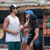 Isis Valverde e o namorado apostaram em boné e óculos de sol para o dia de praia