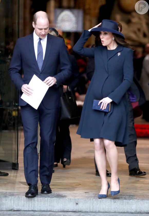 Kate Middleton segura sobretudo ao deixar a Abadia de Westmister, evidenciando a barriga de gravidez