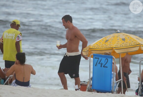 Malvino Salvador bebe uma taça de espumante à beira-mar