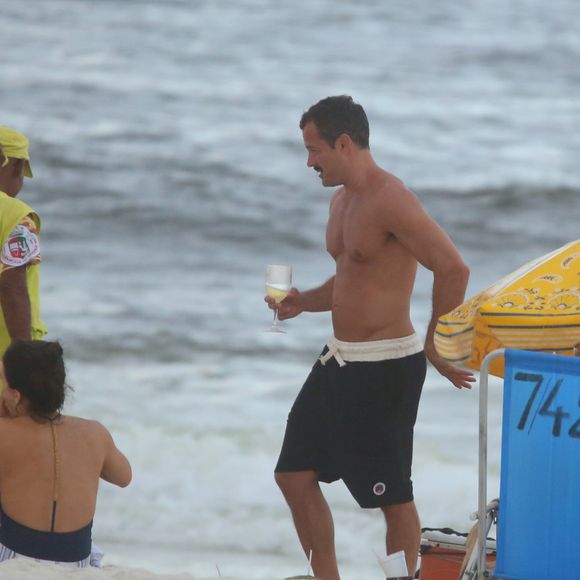 Malvino Salvador bebe uma taça de espumante à beira-mar