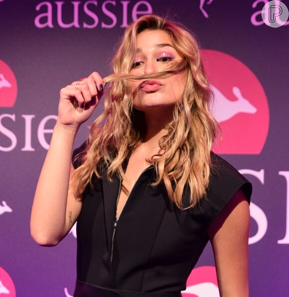 Sasha Meneghel posa brincando com o cabelo em evento da marca Aussie, da qual é a nova embaixadora