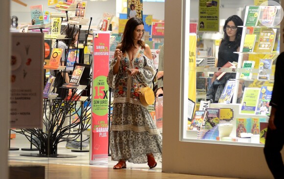 Fátima Bernardes observa vitrine de livraria durante passeio na Barra da Tijuca