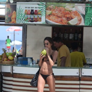 Izabel Goulart bebe água de coco enquanto deixa praia de Copacabana