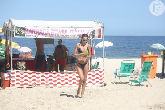 Izabel Goulart volta para cadeira de praia após comprar água de coco