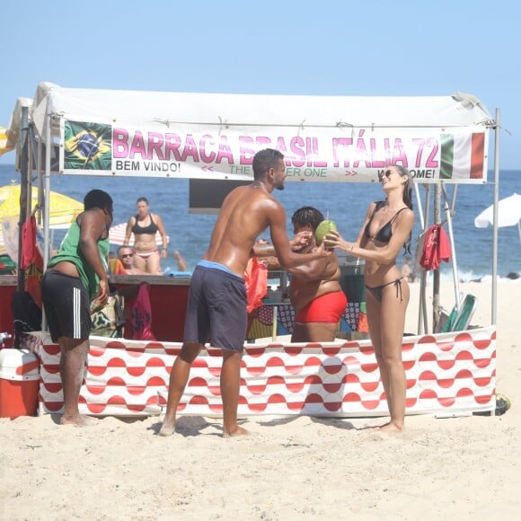 Izabel Goulart conversa com vendedor ao comprar água de coco em Copacabana