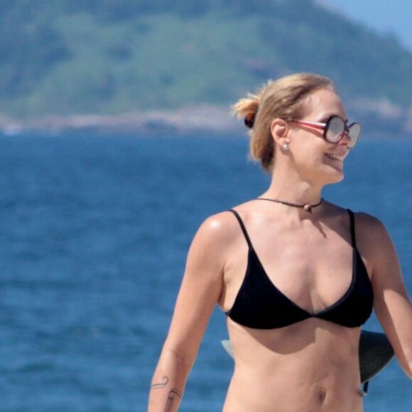 Carolina Ferraz se protegeu do sol forte com óculos escuros e chapéu