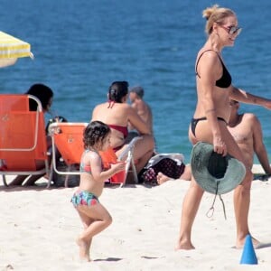 Carolina Ferraz foi à Praia de Ipanema, no Rio, com a filha