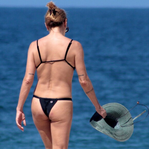 Carolina Ferraz esbajou boa forma aos 50 anos enquanto caminhava pela praia de Ipanema, Zona Sul do Rio de Janeiro