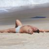 Marcos Frota deita na areia após mergulho no mar