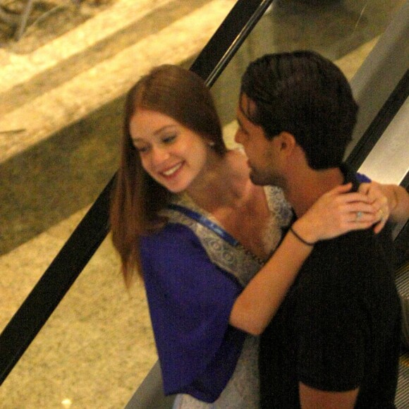 Marina Ruy Barbosa e o marido, Xandinho Negrão, descem escada rolante abraçados