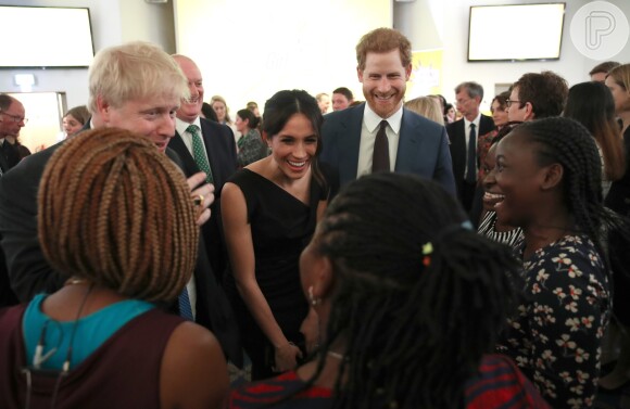 Meghan Markle sorri ao conversar com jovens em evento na companhia de Príncipe Harry