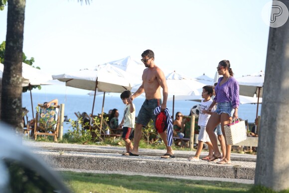 Juliana Paes vestiu uma bata roxa para deixar a praia com os filhos e o marido