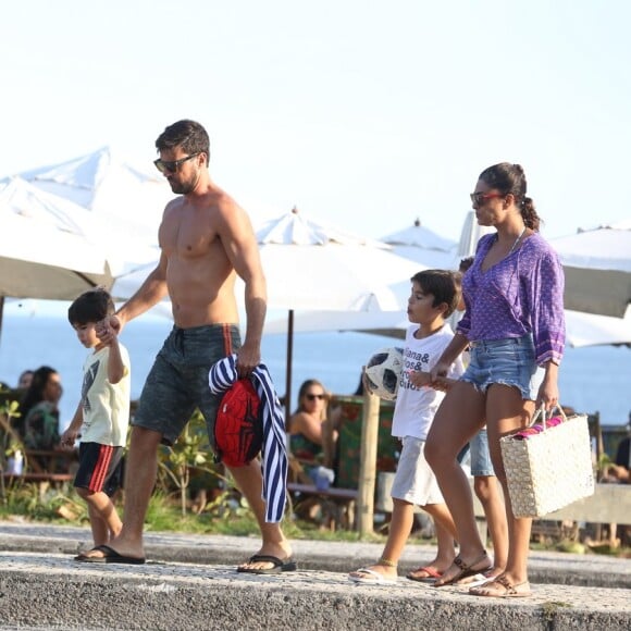 Juliana Paes vestiu uma bata roxa para deixar a praia com os filhos e o marido