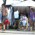 Juliana Paes atravessa calçadão da praia da Barra da Tijuca com marido e filhos