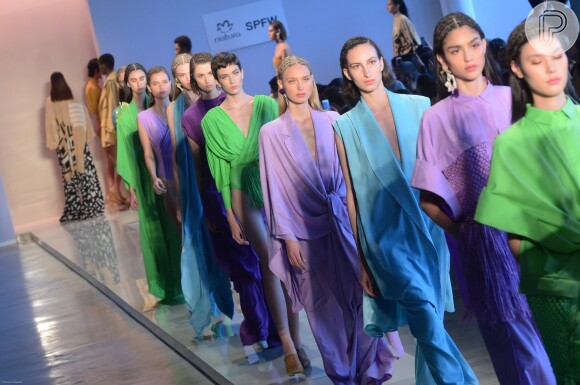 Modelos desfilam durante o evento de moda com cores vibrantes e apostas de tons na moda