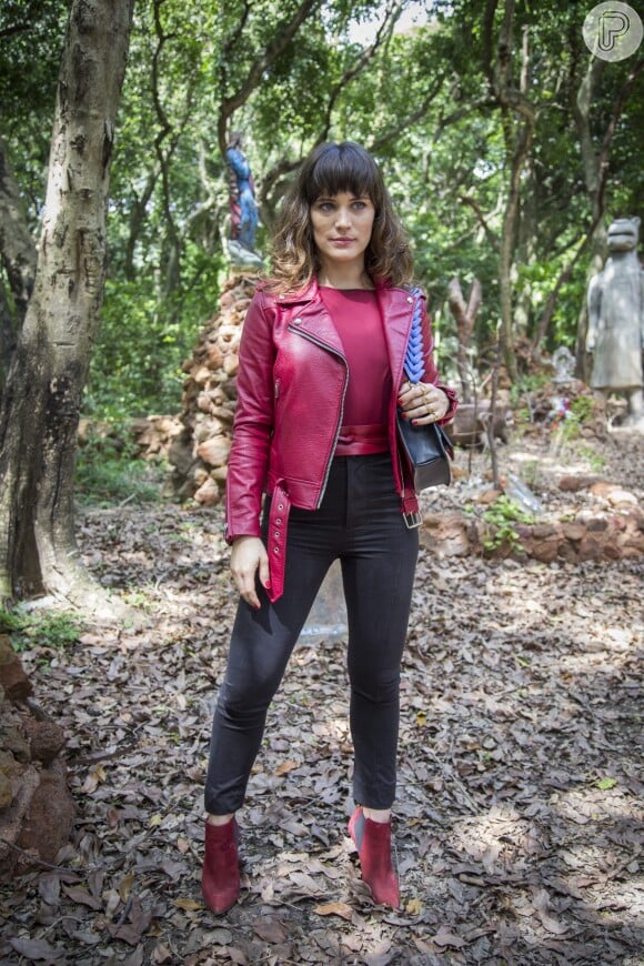 Clara (Bianca Bin) apostou em body vinho, jaqueta vermelha e botas também vermelhas para uma visita em Pedra Santa na novela 'O Outro Lado do Paraíso'