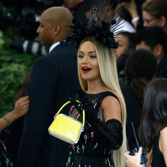Rita Ora ornou vestido preto fluído com bolsa amarela 