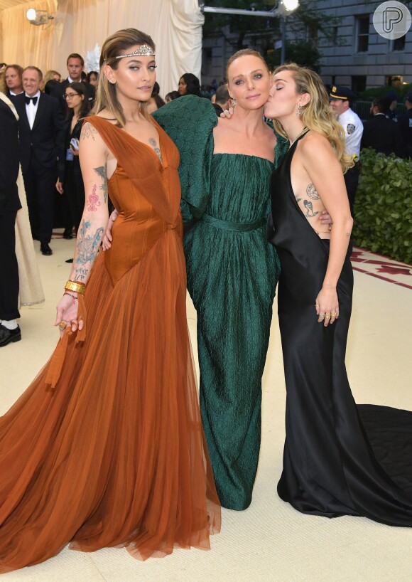 Paris Jackson posa com a designer Stella McCartney, responsável por seu look, e Miley Cyrus no Met Gala 2018