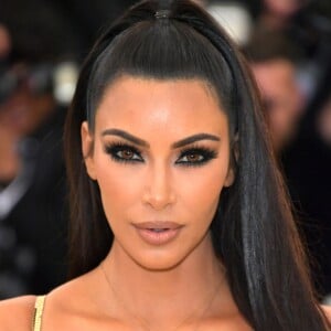 Kim Kardashian apostou no penteado rabo de cavalo superalto e adotou lentes de contato marrom