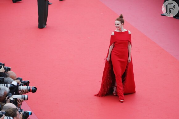 Julianne Moore exibiu um vestido vermelho Givenchy Couture feito sob medida para o Festival de Cannes 2018 com capa, plumas e recortes nos ombros