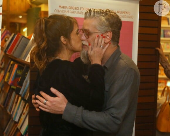 Fábio Assunção abraça Maria Ribeiro ao beijá-la em lançamento do novo livro dela