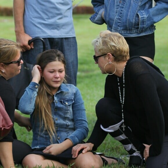 Xuxa consolou Nikki Meneghel no enterro da mãe, dona Alda, sendo observada pela filha, Sasha