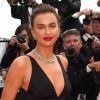 A modelo Irina Shayk escolheu um look preto da grife italiana Twinset com abertura em 'V' no colo e nas costas para prestigiar a exibição do filme 'Yomeddine' no Festival de Cannes 2018