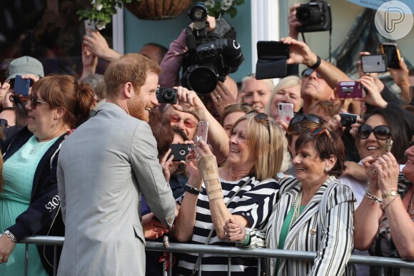 Príncipe Harry atraiu sorrisos de admiradores ao interagir por alguns minutos com locais na véspera de seu casamento