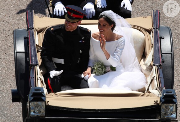 Meghan Markle e o príncipe Harry em cortejo após o casamento em capela de Windsor